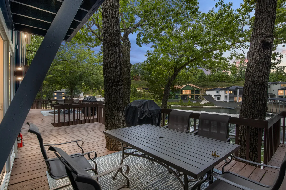 A cozy outdoor dining area with a table nestled among trees and a panoramic water view. The space is set for sunset dinners or peaceful mornings, allowing guests—and their pets—to enjoy the scenic surroundings and gentle ambiance of the cove.